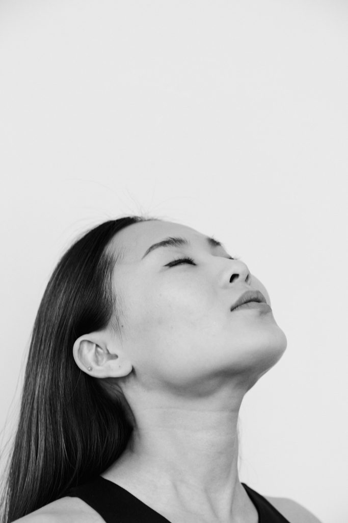 Side profile of a serene woman with eyes closed, captured in black and white.